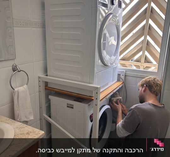אדם מתקן מכונת כביסה בחדר אמבטיה